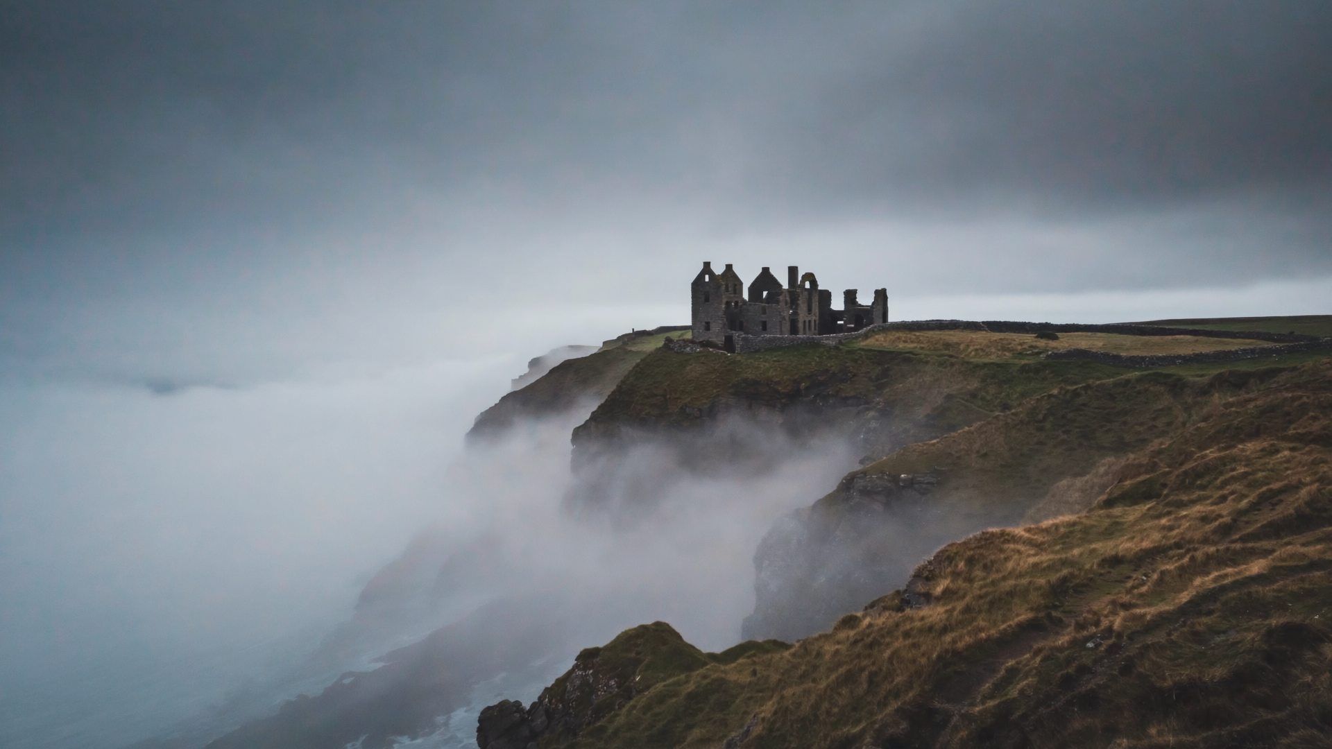 Misty Cornish engine house on cliff edge overlooking the Atlantic